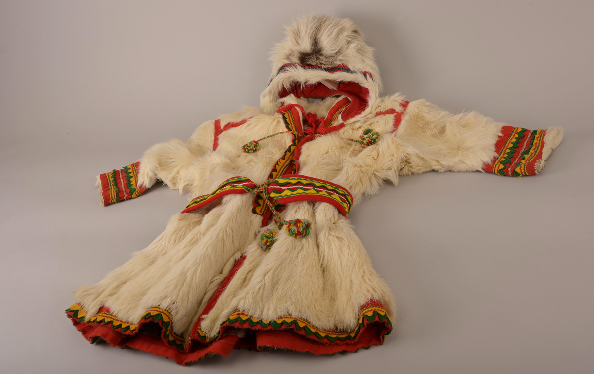 Pesk av pels skinn med lue og belte. Pesken har strammebånd rundt halsen og glidelås til gjenknepping. Skinnet er av enten kalv eller geit. Hårene er for mjuke og ikke hule, slik voksne reinsdyr har. På ryggen av pesken er skinnet strammet inn og her er innfelt røde bånd som fungerer som dekorering. Pesken er foret med rødrutet for.
Luen er av reinsdyrskinn. Beltet er av bomull.