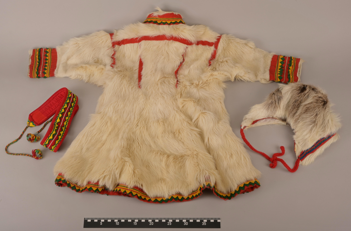 Pesk av pels skinn med lue og belte. Pesken har strammebånd rundt halsen og glidelås til gjenknepping. Skinnet er av enten kalv eller geit. Hårene er for mjuke og ikke hule, slik voksne reinsdyr har. På ryggen av pesken er skinnet strammet inn og her er innfelt røde bånd som fungerer som dekorering. Pesken er foret med rødrutet for.
Luen er av reinsdyrskinn. Beltet er av bomull.