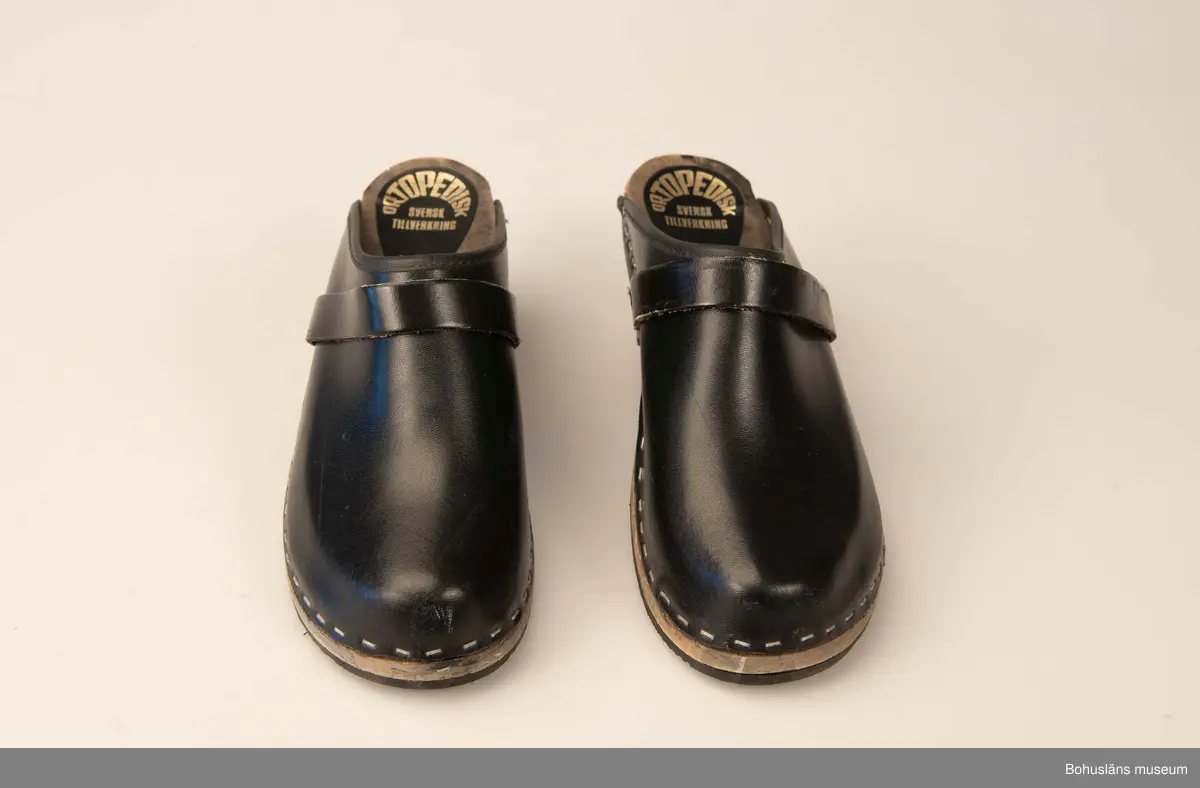 Storlek 39. Ortopediska. Svensk tillverkning. Svartbetsad träsula, svart ovanläder. 
Använda av sillskärerskor vid ABBA konservfabrik i Lysekil.