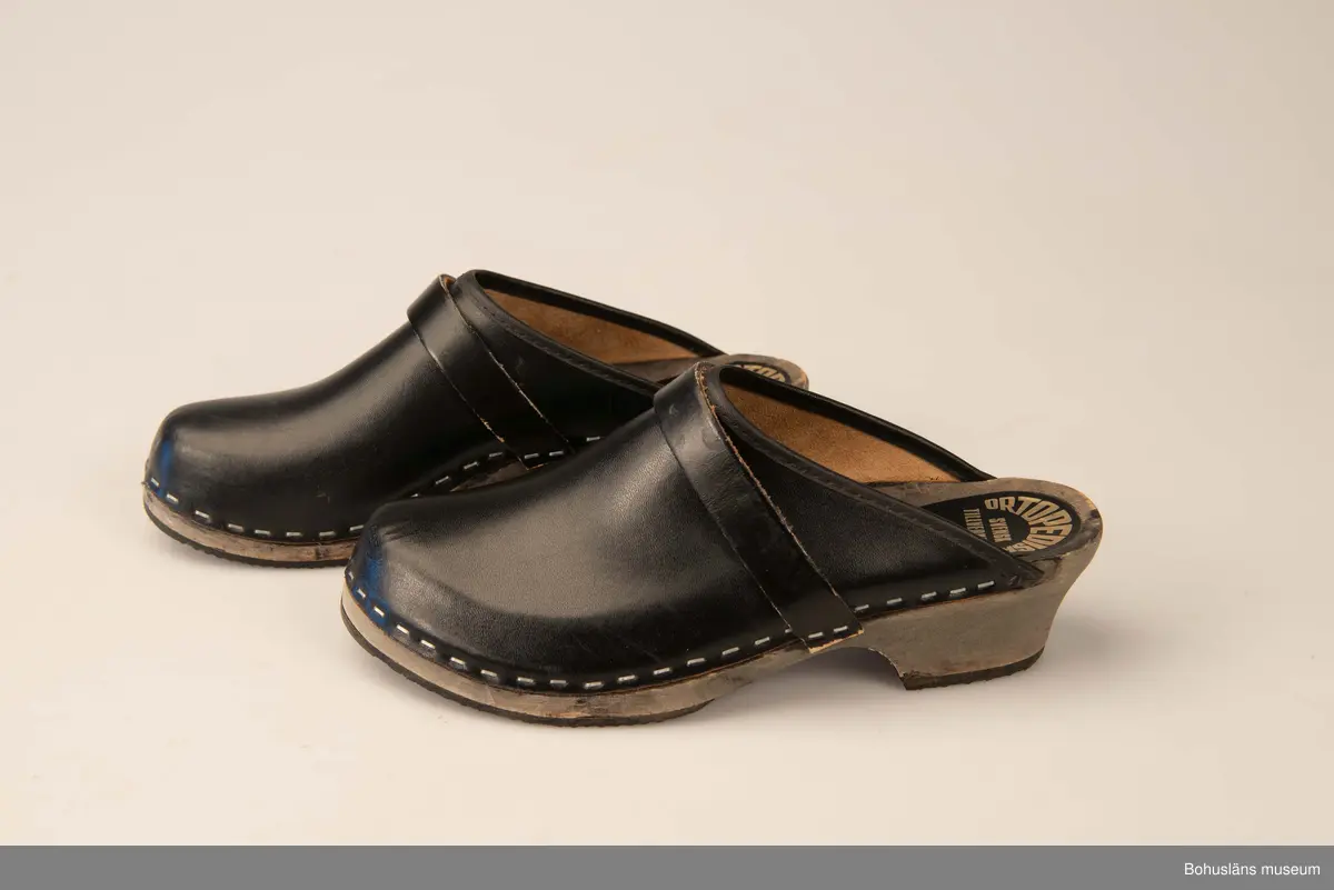 Storlek 39. Ortopediska. Svensk tillverkning. Svartbetsad träsula, svart ovanläder. 
Använda av sillskärerskor vid ABBA konservfabrik i Lysekil.