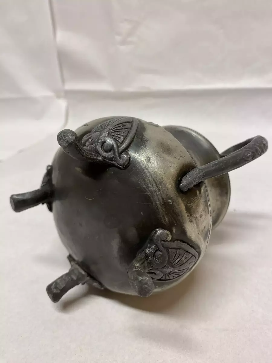 Sukkerkopp tinn med to hanker. 
Mulig del av et sett med kanne og fløtemugge. Kanna er under stempla med WARRANTED BEST ELECTRO PLATE, 28013, 6. Sukkerkopp og fløtemugge har ingen stempel. 

Hank og 4 føtter har utpressede bladornament. På korpus er det også gravert inn mønster (border). 