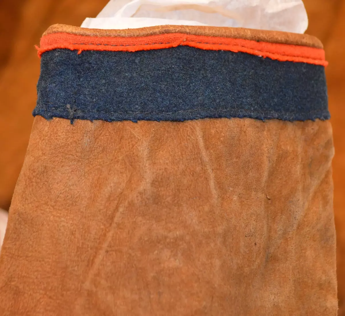 Sválltjá/kinnkofte med tekstilapplikasjoner og grindvevd pyntebånd. Goahkka/Krage i vinrød bunnfarge, uten divlle, men dekor øverst i grønt og gult. Badjelbuttas i goahkka/krage er mørkeblå. Åhtså med sájá i rødt og blått. Sase/ermedekor med sájá i blått og rødt og med badjelbuttas i brunt skinn. Nederst påsydd snjisjkodum/vevd lissto/kantband.