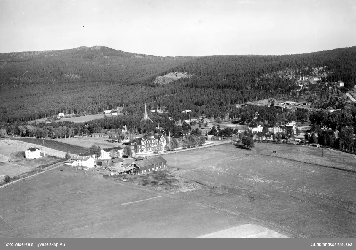 Flyfoto over Dombås sentrum med Dombås Turisthotel og Dombåsgarden fremst.