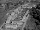 Flygfoto över Avesta 1958. Jämtbovägen. Corneliusgatan. Avesta kallbadhus i bakgrunden. Villor ritade av Ralph Erskin till vänster i bild.