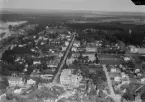 Flygfoto över Avesta 1935-1937. Kungsgatan. Avesta stadshus och stadshusparken. Vattentorn. Karlbergsparken. Gamla bruksklubben. Kyrkogatan i förgrunden.