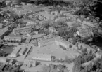 Flygfoto över Avesta 1962. Markusskolan och gymnastiksalen i mitten, med badhus till vänster. Stadshus och stadshusparken, Corneliusgatan.