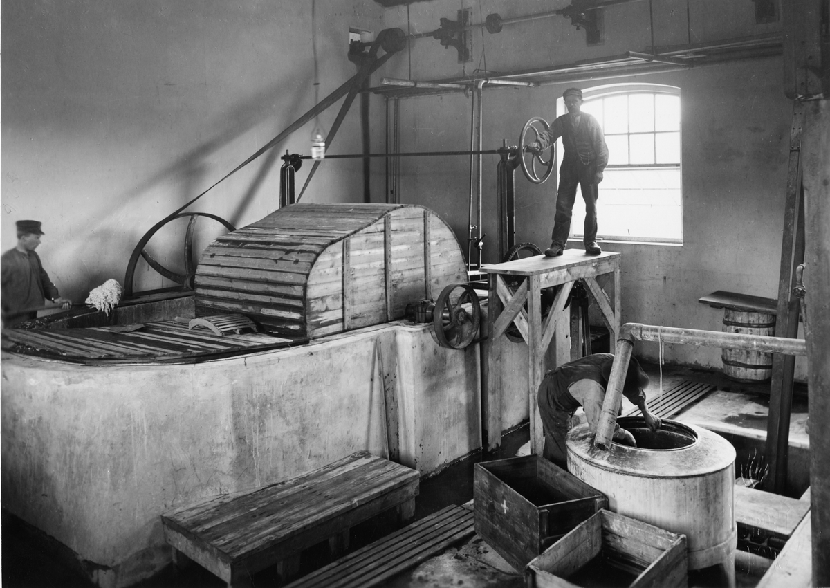 AB Bofors Nobelkrut. Stabilisering av bomullskrut (nitrocellulosa). Till vänster en kokhällare, i vilken den malda nitrocellulosan kokas, tills den blir fullkomligt stabil och sålunda kan utan risk upplagras. Till höger en centrifug för vattnets avdrivande. 1908.
