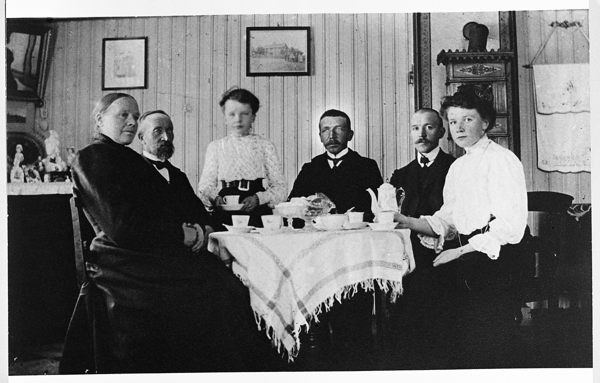 Andrine, Johannes, Anna, Bernhard, Matias og Marie Skinderviken samlet rundt et bord, trolig på Skinderviken, Eina, 20/4-1908.