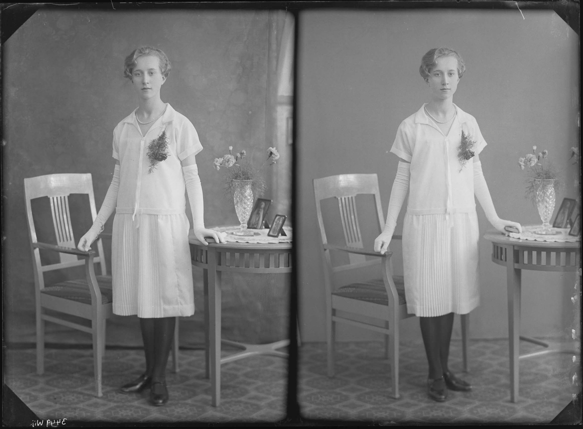 Fotografering beställd av Iris Grönberg. Föreställer Iris Paulina Grönberg (1912-1986) på Nygård 1-3C i Västerås. Konfirmation.