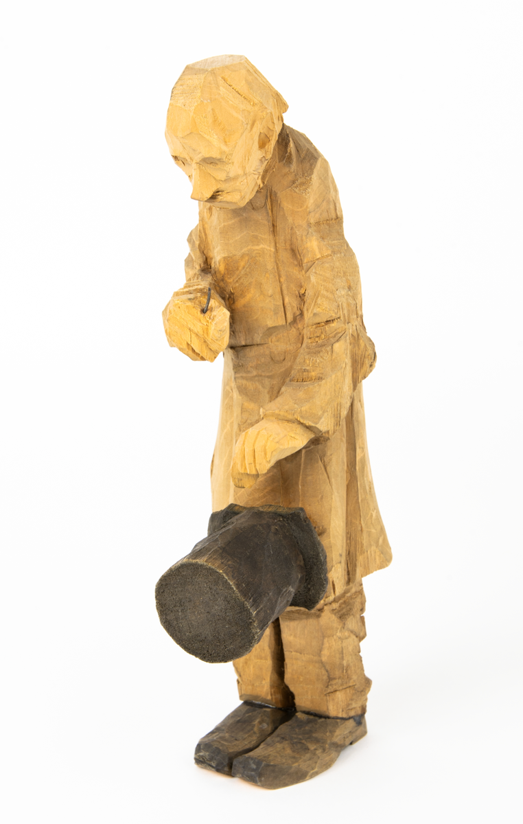 Skulpturgrupp "Begravningen", bestående av 8 objekt föreställande 6 män en präst, en kvinna samt en kista på bockar. 
Gruppens figurer: 
1. Dödgrävare Hultgren i rock och med hatt i handen. H 256 mm.
2. Svartklädd bärare som håller en hatt. H 234 mm. 
3. Svartklädd bärare som håller en hatt. H 240 mm. 
4. Svartklädd bärare som håller en hatt. H 140 mm. 
5. Klockare Sjöström som håller en hatt. H 265 mm.
6. Prosten Arbman med mantelsläpet runt ena armen. I vänstra hande håller han en uppslagen bibel och i den andra skall han hålla en skopa (vilken saknas). H 272 mm.
7. Den sörjande änka i svart klänning och schal och vit näsduk. H 238 mm.
8. En kista på två bockar, L 290 mm.