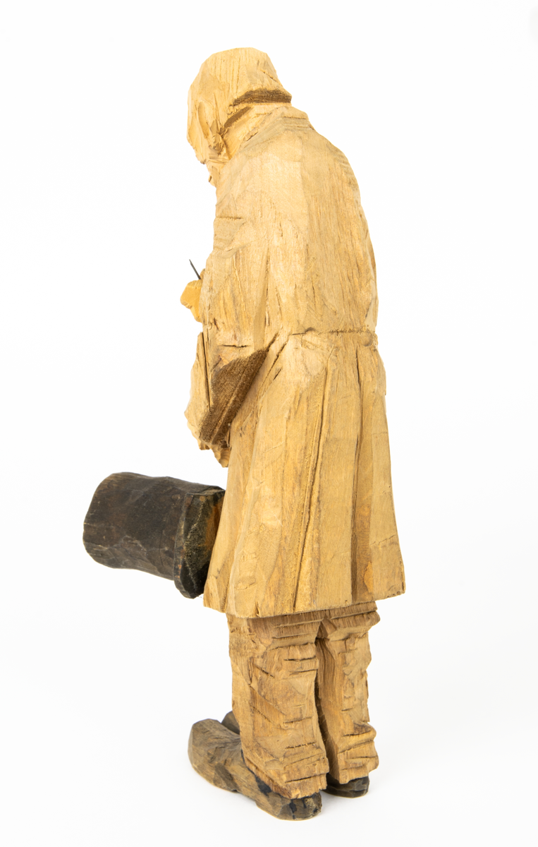 Skulpturgrupp "Begravningen", bestående av 8 objekt föreställande 6 män en präst, en kvinna samt en kista på bockar. 
Gruppens figurer: 
1. Dödgrävare Hultgren i rock och med hatt i handen. H 256 mm.
2. Svartklädd bärare som håller en hatt. H 234 mm. 
3. Svartklädd bärare som håller en hatt. H 240 mm. 
4. Svartklädd bärare som håller en hatt. H 140 mm. 
5. Klockare Sjöström som håller en hatt. H 265 mm.
6. Prosten Arbman med mantelsläpet runt ena armen. I vänstra hande håller han en uppslagen bibel och i den andra skall han hålla en skopa (vilken saknas). H 272 mm.
7. Den sörjande änka i svart klänning och schal och vit näsduk. H 238 mm.
8. En kista på två bockar, L 290 mm.