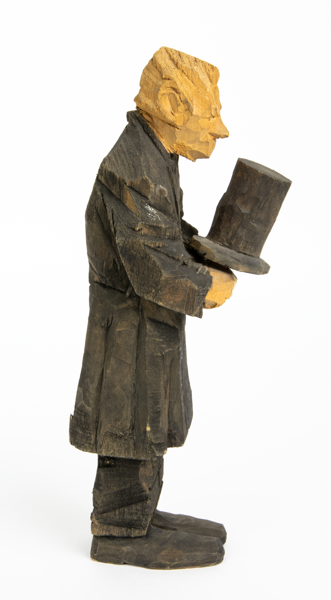 Skulpturgrupp "Begravningen", bestående av 8 objekt föreställande 6 män en präst, en kvinna samt en kista på bockar. 
Gruppens figurer: 
1. Dödgrävare Hultgren i rock och med hatt i handen. H 256 mm.
2. Svartklädd bärare som håller en hatt. H 234 mm. 
3. Svartklädd bärare som håller en hatt. H 240 mm. 
4. Svartklädd bärare som håller en hatt. H 140 mm. 
5. Klockare Sjöström som håller en hatt. H 265 mm.
6. Prosten Arbman med mantelsläpet runt ena armen. I vänstra hande håller han en uppslagen bibel och i den andra skall han hålla en skopa (vilken saknas). H 272 mm.
7. Den sörjande änka i svart klänning och schal och vit näsduk. H 238 mm.
8. En kista på två bockar, L 290 mm.