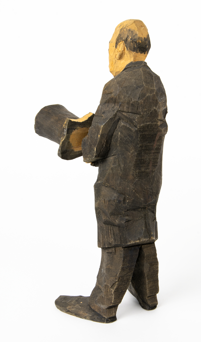 Skulpturgrupp "Begravningen", bestående av 8 objekt föreställande 6 män en präst, en kvinna samt en kista på bockar. 
Gruppens figurer: 
1. Dödgrävare Hultgren i rock och med hatt i handen. H 256 mm.
2. Svartklädd bärare som håller en hatt. H 234 mm. 
3. Svartklädd bärare som håller en hatt. H 240 mm. 
4. Svartklädd bärare som håller en hatt. H 140 mm. 
5. Klockare Sjöström som håller en hatt. H 265 mm.
6. Prosten Arbman med mantelsläpet runt ena armen. I vänstra hande håller han en uppslagen bibel och i den andra skall han hålla en skopa (vilken saknas). H 272 mm.
7. Den sörjande änka i svart klänning och schal och vit näsduk. H 238 mm.
8. En kista på två bockar, L 290 mm.