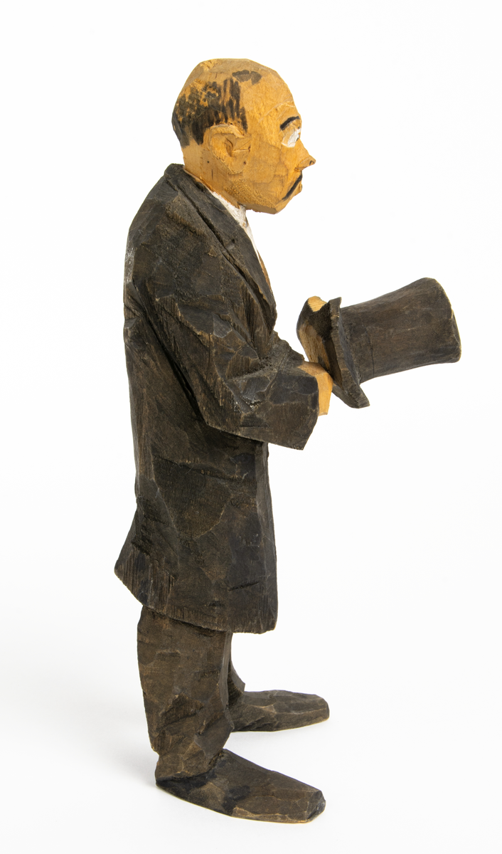 Skulpturgrupp "Begravningen", bestående av 8 objekt föreställande 6 män en präst, en kvinna samt en kista på bockar. 
Gruppens figurer: 
1. Dödgrävare Hultgren i rock och med hatt i handen. H 256 mm.
2. Svartklädd bärare som håller en hatt. H 234 mm. 
3. Svartklädd bärare som håller en hatt. H 240 mm. 
4. Svartklädd bärare som håller en hatt. H 140 mm. 
5. Klockare Sjöström som håller en hatt. H 265 mm.
6. Prosten Arbman med mantelsläpet runt ena armen. I vänstra hande håller han en uppslagen bibel och i den andra skall han hålla en skopa (vilken saknas). H 272 mm.
7. Den sörjande änka i svart klänning och schal och vit näsduk. H 238 mm.
8. En kista på två bockar, L 290 mm.