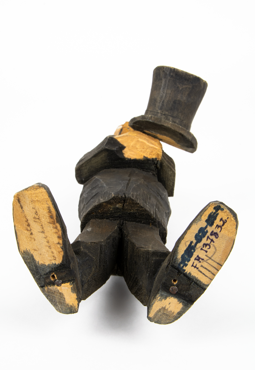 Skulpturgrupp "Begravningen", bestående av 8 objekt föreställande 6 män en präst, en kvinna samt en kista på bockar. 
Gruppens figurer: 
1. Dödgrävare Hultgren i rock och med hatt i handen. H 256 mm.
2. Svartklädd bärare som håller en hatt. H 234 mm. 
3. Svartklädd bärare som håller en hatt. H 240 mm. 
4. Svartklädd bärare som håller en hatt. H 140 mm. 
5. Klockare Sjöström som håller en hatt. H 265 mm.
6. Prosten Arbman med mantelsläpet runt ena armen. I vänstra hande håller han en uppslagen bibel och i den andra skall han hålla en skopa (vilken saknas). H 272 mm.
7. Den sörjande änka i svart klänning och schal och vit näsduk. H 238 mm.
8. En kista på två bockar, L 290 mm.