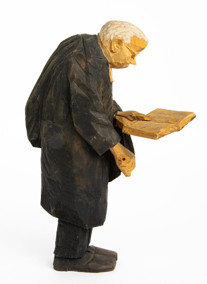Skulpturgrupp "Begravningen", bestående av 8 objekt föreställande 6 män en präst, en kvinna samt en kista på bockar. 
Gruppens figurer: 
1. Dödgrävare Hultgren i rock och med hatt i handen. H 256 mm.
2. Svartklädd bärare som håller en hatt. H 234 mm. 
3. Svartklädd bärare som håller en hatt. H 240 mm. 
4. Svartklädd bärare som håller en hatt. H 140 mm. 
5. Klockare Sjöström som håller en hatt. H 265 mm.
6. Prosten Arbman med mantelsläpet runt ena armen. I vänstra hande håller han en uppslagen bibel och i den andra skall han hålla en skopa (vilken saknas). H 272 mm.
7. Den sörjande änka i svart klänning och schal och vit näsduk. H 238 mm.
8. En kista på två bockar, L 290 mm.