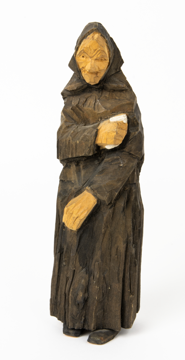 Skulpturgrupp "Begravningen", bestående av 8 objekt föreställande 6 män en präst, en kvinna samt en kista på bockar. 
Gruppens figurer: 
1. Dödgrävare Hultgren i rock och med hatt i handen. H 256 mm.
2. Svartklädd bärare som håller en hatt. H 234 mm. 
3. Svartklädd bärare som håller en hatt. H 240 mm. 
4. Svartklädd bärare som håller en hatt. H 140 mm. 
5. Klockare Sjöström som håller en hatt. H 265 mm.
6. Prosten Arbman med mantelsläpet runt ena armen. I vänstra hande håller han en uppslagen bibel och i den andra skall han hålla en skopa (vilken saknas). H 272 mm.
7. Den sörjande änka i svart klänning och schal och vit näsduk. H 238 mm.
8. En kista på två bockar, L 290 mm.
