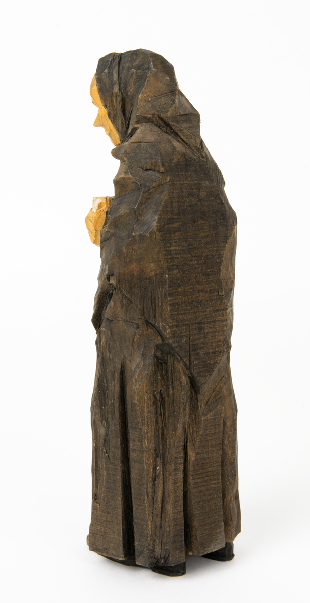 Skulpturgrupp "Begravningen", bestående av 8 objekt föreställande 6 män en präst, en kvinna samt en kista på bockar. 
Gruppens figurer: 
1. Dödgrävare Hultgren i rock och med hatt i handen. H 256 mm.
2. Svartklädd bärare som håller en hatt. H 234 mm. 
3. Svartklädd bärare som håller en hatt. H 240 mm. 
4. Svartklädd bärare som håller en hatt. H 140 mm. 
5. Klockare Sjöström som håller en hatt. H 265 mm.
6. Prosten Arbman med mantelsläpet runt ena armen. I vänstra hande håller han en uppslagen bibel och i den andra skall han hålla en skopa (vilken saknas). H 272 mm.
7. Den sörjande änka i svart klänning och schal och vit näsduk. H 238 mm.
8. En kista på två bockar, L 290 mm.