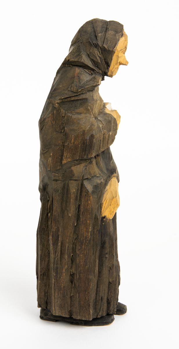 Skulpturgrupp "Begravningen", bestående av 8 objekt föreställande 6 män en präst, en kvinna samt en kista på bockar. 
Gruppens figurer: 
1. Dödgrävare Hultgren i rock och med hatt i handen. H 256 mm.
2. Svartklädd bärare som håller en hatt. H 234 mm. 
3. Svartklädd bärare som håller en hatt. H 240 mm. 
4. Svartklädd bärare som håller en hatt. H 140 mm. 
5. Klockare Sjöström som håller en hatt. H 265 mm.
6. Prosten Arbman med mantelsläpet runt ena armen. I vänstra hande håller han en uppslagen bibel och i den andra skall han hålla en skopa (vilken saknas). H 272 mm.
7. Den sörjande änka i svart klänning och schal och vit näsduk. H 238 mm.
8. En kista på två bockar, L 290 mm.