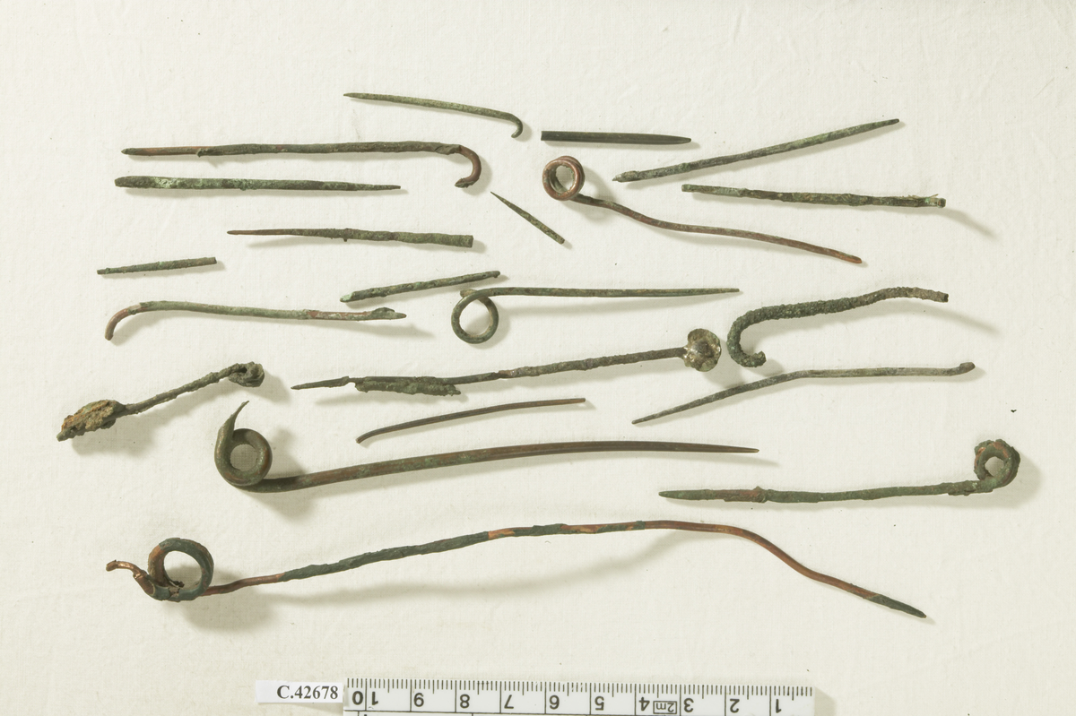 21 pins and fragment of pins belonging to fibulae. Most of them from later restaurations. Some of the pins are made of copper wire coated with green colour to give them a "patina".