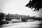 Oscar Fredriks bro över Motala ström i centrala Norrköping. Den öppna platsen i förgrunden kallades Fisktorget. På motsatt sida skymtar Kungliga telegrafstationen. Odaterad bild från omkring 1895.