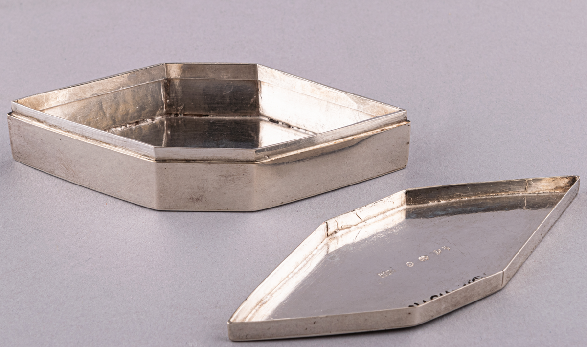 Silverdosor, 2st, sexkantiga. Lock utan gångjärn.
Helt utan ornamentik. Stämplar i dosornas botten och i locken: P2, G, kattfot, POB (=P.O. Bäckström 1821). Pehr Olof Bäckström 1812-1834.
L 10cm, BR 4,1cm, H 2cm (med lock). Lockets H 0,6cm.