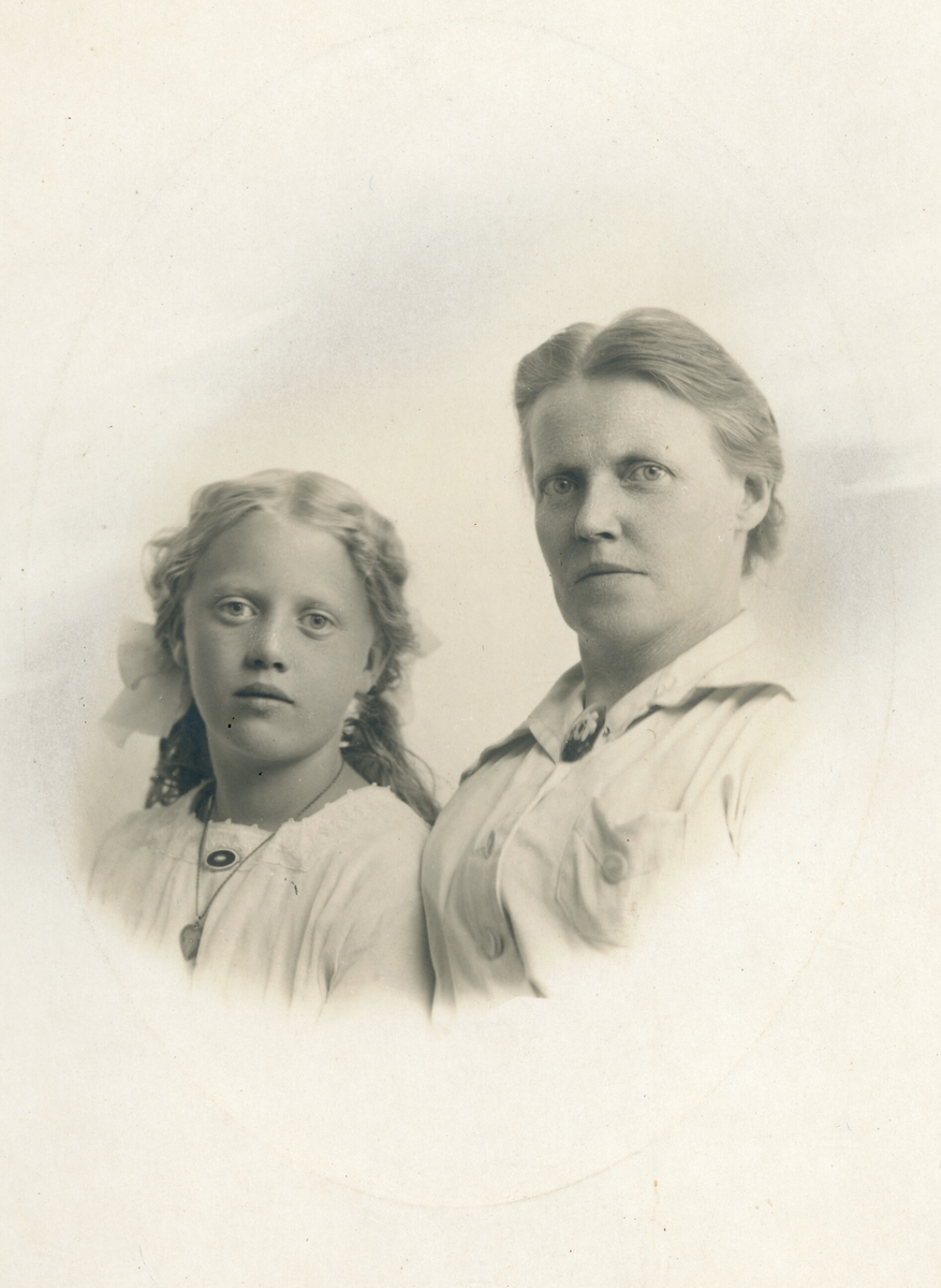 Portrettfoto av kvinne og jente, truleg mor og dotter.