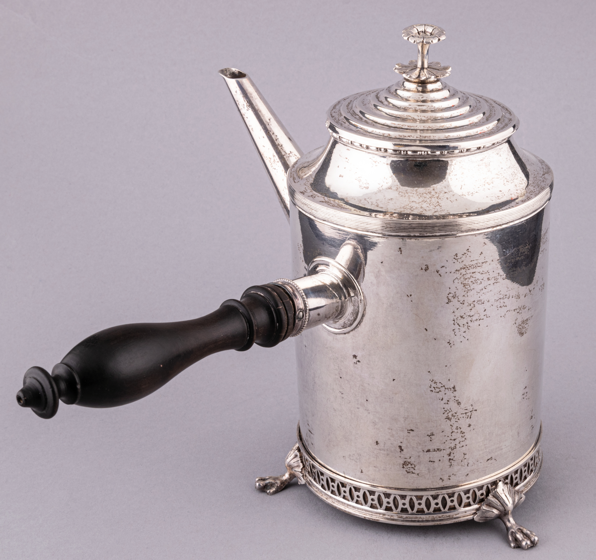 Gustaviansk kaffekanna i silver, med svarvat svart trähandtag och tre fyrtåiga fötter.