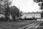 Vy över planen framför Linköpings domkyrka med blicken vänd mot nordväst. Till vänster gymnastikhuset till stadens läroverk, uppfört under åren 1880-81. I fonden den så kallade Konsistoriegården med säte för domkapitlet.