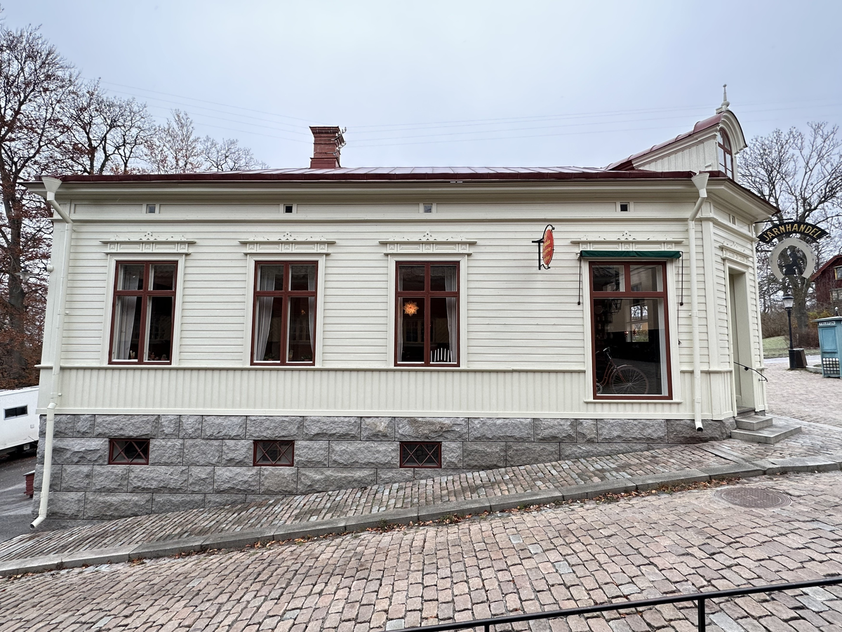 Järnhandlarens hus i Skansens stadskvarter är till sin fasad uppfört efter förlagan på Repslagargatan 8 (Modisten 3) i Hudiksvall. Stommen är modern. 

Byggnaden är uppförd i en våning, med källare i souterräng, grunden är av huggen natursten. Fasaden är klädd med liggande panel målad i en ljust vit kulör. Fasaden delas in av lisener vid det avskurna hörnet, samt med horisontell mittelbandslist i fönstrens underkant samt som en artikulering av vindsvåningen. Taket är brutet och klätt med rödmålad plåt. Vid det avskurna hörnet finns en takkupa med rundat överstycke, snickarglädje samt spira. Byggnaden har två murade skorstenar i tegel.

 Järnhandlarens hus rymmer en järnhandel med kontor, en järnhandlarbostad samt en konsumbutik. 

Byggnaden uppfördes på Skansen under åren 2004-2005.
