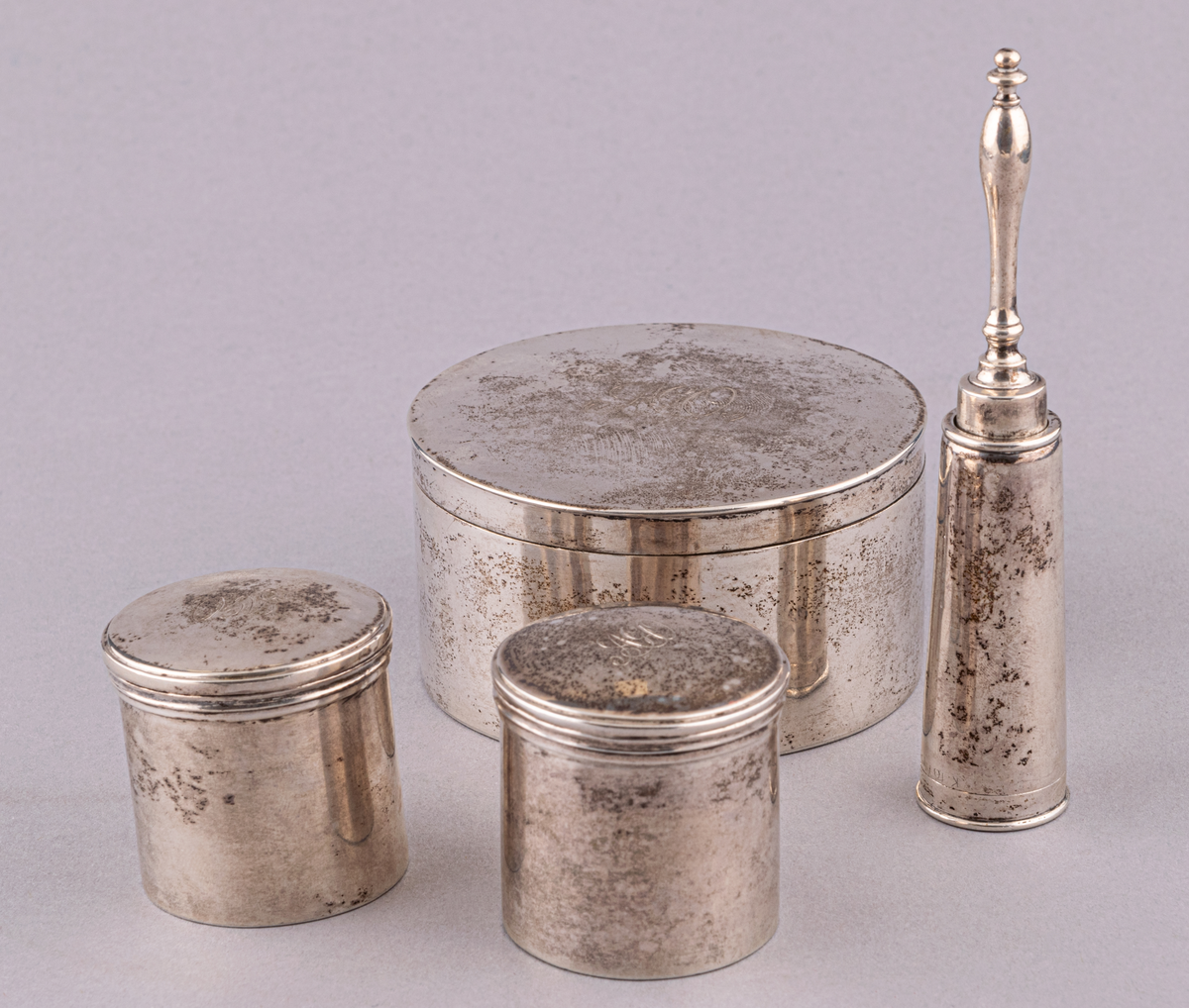 Innehåll till resenessäsär, rakborste i silverfodral, 3 runda askar av silver, på locken monogram: A.G.O, hårborste.