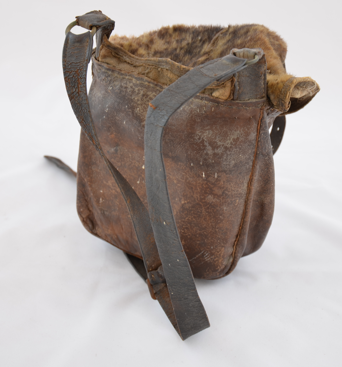 Jaktveske i selskinn. Er delvis uttørka og er dermed stiv og uhandterleg. Pelsen på skinnet er i ferd med å losne og må handterast forsiktig. Veska inneheld to kammer, eit fremre og eit bakre. Det er berre loket som er laga av pelskledd skinn.
