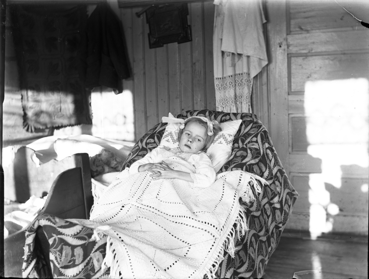 Fotosamling etter Kjetil Skomdal (1881-1971). Fotografen virket i perioden 1910 til 1960 og hadde eget mørkerom hvor han også tok imot film fra andre fotografer. I perioden var han også postbud i Fyresdal. Bilde viser portrett av syk pike