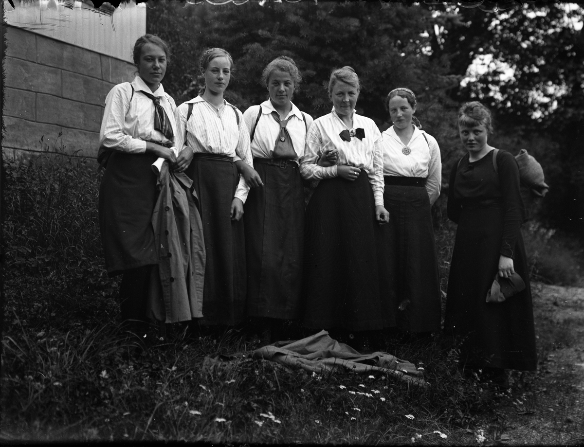 Fotosamling etter Bendik Ketilson Taraldlien (1863-1951) Fyresdal. Gårdbruker, fotograf og skogbruksmann. Fotosamlingen etter fotograf Taraldlien dokumenterer områdene Fyresdal og omegn. 
Gruppeportrett, kvinner i hagen til Taraldlien, på vei til Gausdalsetra.