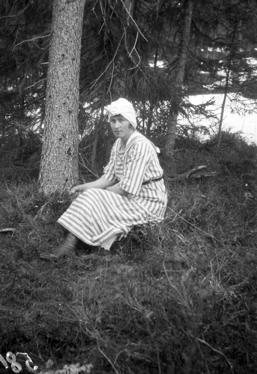 Bilde viser portrett av Dagny Jonsjord, født Farsjø, Sannidal, på ei tuve i skogen

Fotosamling etter Øystein O. Jonsjords (1895-1968), Tinn.