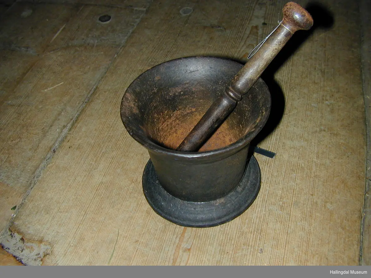 Mortar med innoverskrånande fot. Deretter lett utoverskrånande veggar. Mortaren har sirkulært tverrsnitt.
Knusaren har sirkulært tverrsnitt. Ei kule i kvar ende, ein ring på midten.