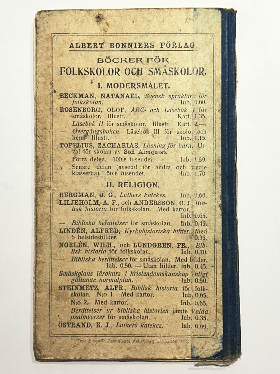 Läsebok för ämnet kristendom med häftat, jämnskuret klotryggband på totalt 36 sidor. Omslaget är tryckt i blå färg med titel och förlagsuppgifter, samt utsirad kantbård. Ryggklotet i mörkt blå färg, med synlig, naturfärgad häfttråd. Boken är något sliten i rygg och i hörnen framtill. På baksidan är listat titlar hos förlaget för folkskolor och småskolor i olika ämnen. Inuti finns ett flertal pressade blomblad, samt rester av ett metallpapper, nu i smulor.