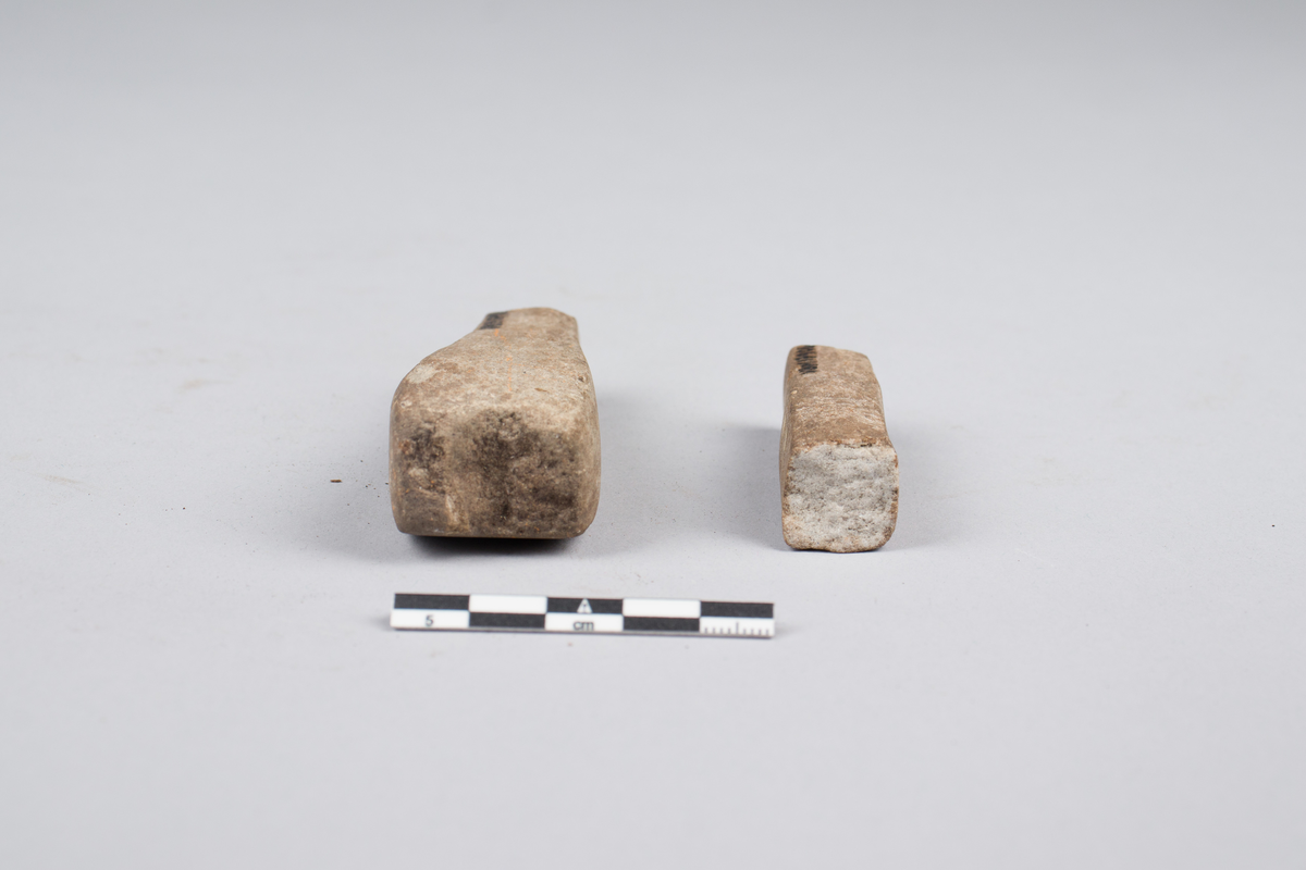 Bryne eller hein til sliping av redskaper. Brukket opp i flere deler. Kun to av delene inngår i samlingen. Resten er tapt. Firkantet tversnitt, bredere i ene enden.