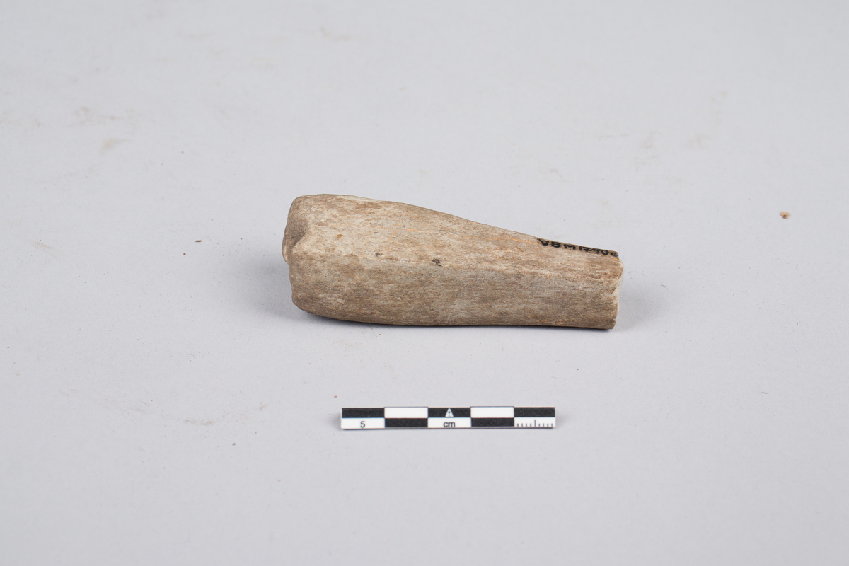Bryne eller hein til sliping av redskaper. Brukket opp i flere deler. Kun to av delene inngår i samlingen. Resten er tapt. Firkantet tversnitt, bredere i ene enden.