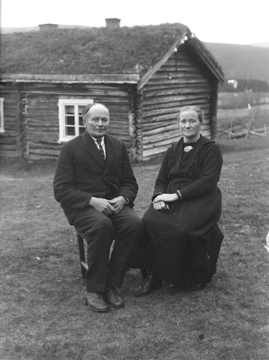 Mann og kvinne foran lita stue