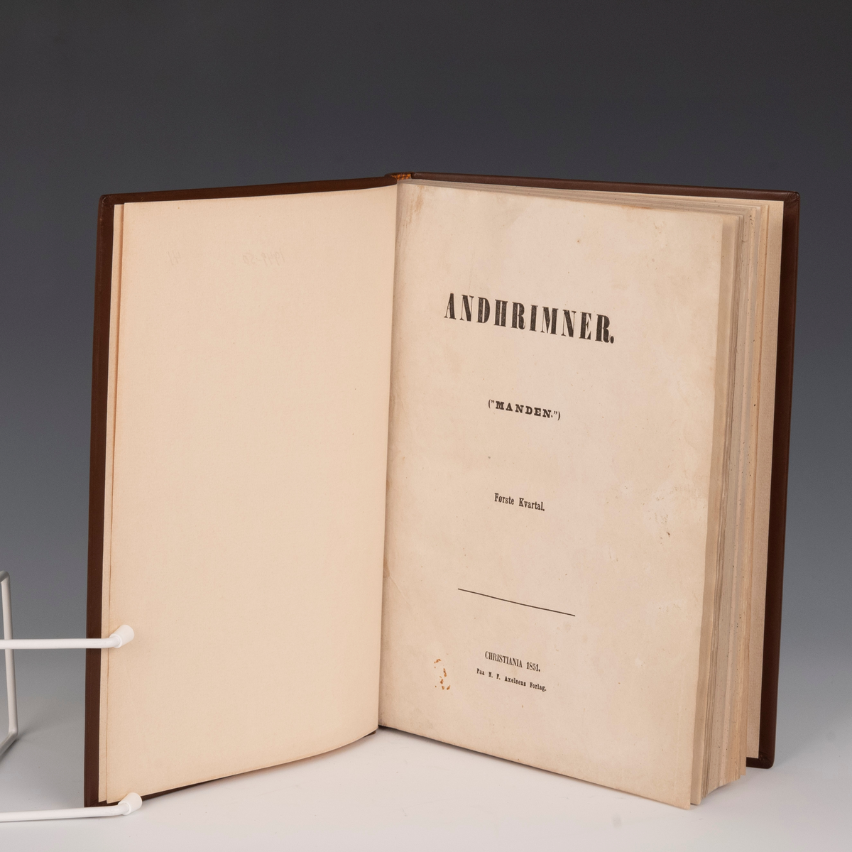Komplett innbundet eksemplar av tidsskriftet Andhrimner/Manden. 

Fra protokollen: 
"Andhrimner" ("Manden"). Første Kvartal. Chr.a. 1851. 2 bl.+nr. 1-13 à 4 bl., 208 sp. - F. 4. 
"Andhrimner" ("Manden"). Andet Kvartal. Chr.a. 1851. 2 bl.+nr. 1-13 à 4 bl., 208 sp. - F. 4.
"Andhrimner" ("Manden"). Tredie Kvartal. Chr.a. 1851. 2 bl.+nr. 1-13 à 4 bl., 208 sp. - F. 4.  
Komplett bibliofil-exemplar i heilskinnsband (av bokb. R. Næss), komponera med vigneter av "Manden" paa utsida av fyrste perm (og paa loket av den papkapslen boki ligg i, laga einslestes), baade band og kapsel i brunt (kapslen i gulbrunt). (R. Berge)