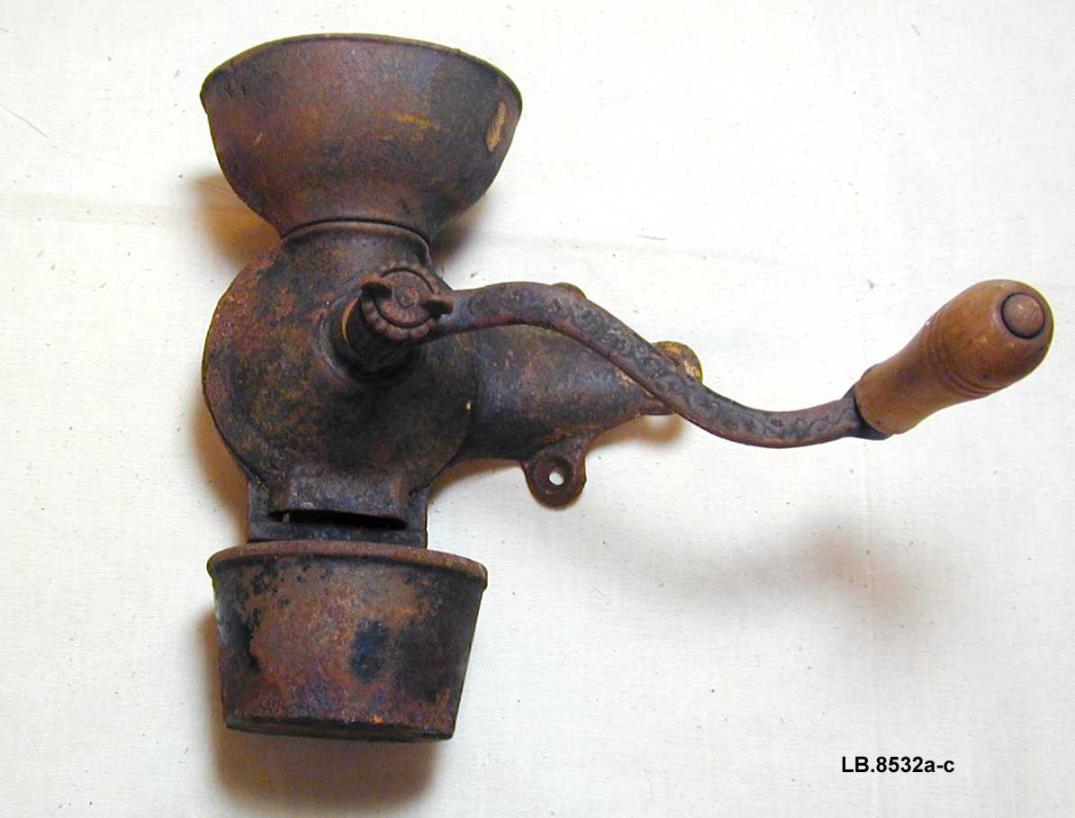 Til å feste på veggen med 3 skruvar. Sveiva er festa midt framme og har trehandtak. Oppsamlingskaret heng i botn og er til å ta av.