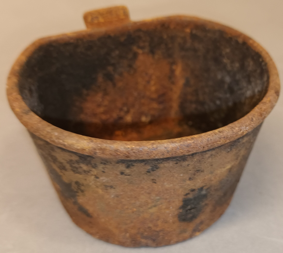 Til å feste på veggen med 3 skruvar. Sveiva er festa midt framme og har trehandtak. Oppsamlingskaret heng i botn og er til å ta av.