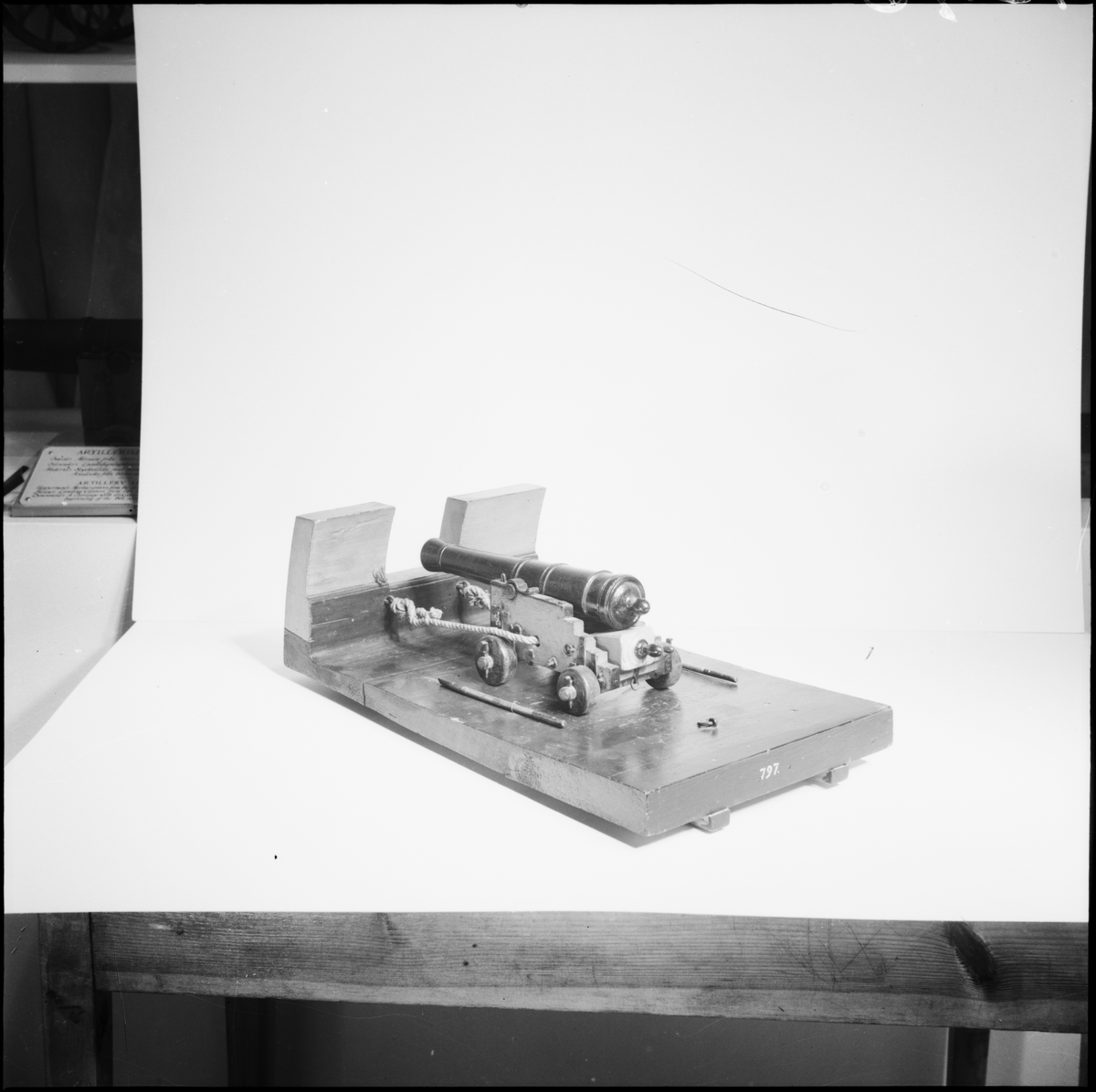 Kanonmodell: 18-pundig styckelåda, med kanon av Tornqvist modell 1757. Lavetten av trä med beslag av järn. Kanonen av trä. Lådan röd, kanon och beslag svartmålade. Tillbehör: 1 st brok, 2 st spaker, 1 st riktkil. Lavetten L = 512 mm B = 275 mm H = 170 mm.