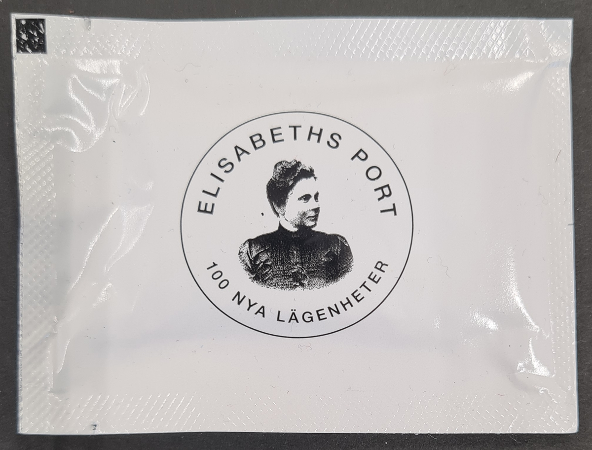 Våtservett i förpackning. På förpackningen finns en bild på Elisabeth Anrep Nordin. Över henne står Elisabeths port, under porträttet, 100 nya lägenheter. På andra sidan av förpackningen står:
Elisabeths port
där drömmar möter verklighet.

Vänersborgsbostäders logga finns med.

Förpackningen är reklam för Vänersborgsbostäder. Ett av deras nyare projekt är huset Elisabeths port, namngivet efter Elisabeth Anrep Nordin.