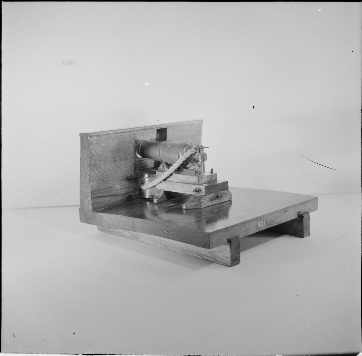 Kanonmodell: 24-pundig karronadlavett av engelsk modell, helt i trä, med karronad. Karronaden svartbetsad, lavetten fernissad. Lavetten L = 345 mm B = 310 mm H = 205 mm.