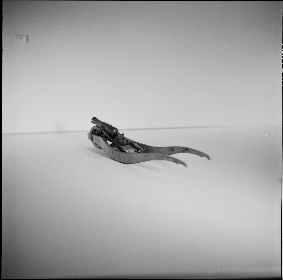 Modell av kanonskottkärra med 2-p metallnicka. Kärran av trä med järnbeslag. Nickan märkt "XII : IV". Tillbehör: 1 st riktkil. Troligen Chapman. Lavetten L = 350 mm B = 85 mm H = 85 mm.