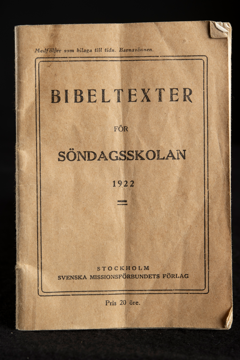 Läsebok med klammerhäftad inbindning, mjukt, oblekt pärmpapper med svart tryck. Boken är något sliten i hörnen och har bland annat ett lodrätt vikmärke på mitten.