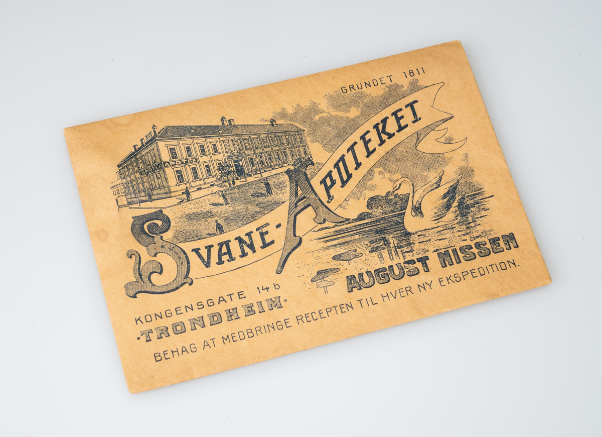 Bygningen "Svaneapoteket". En svane på en sjø med vannliljer e.l., konturer av fjell i bakgrunnen.