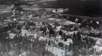 Flygfoto över Ruda med bostadshus, grusväg och järnväg.